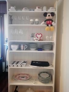 a white cabinet filled with plates and dishes at NANA in Bilbao in Bilbao