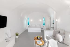 Biały salon z białą kanapą i stołem w obiekcie Marizan Caves & Villas w mieście Oia