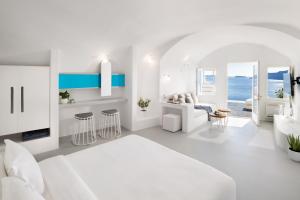 Biała sypialnia z białym łóżkiem i salonem w obiekcie Marizan Caves & Villas w mieście Oia +37 zdjęć