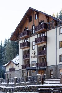 - un grand bâtiment avec des balcons sur le côté dans l'établissement Ganz SKI Lift 5, à Bukovel