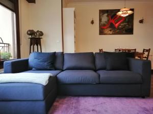 - un canapé bleu dans le salon avec un tapis violet dans l'établissement NANA in Bilbao, à Bilbao