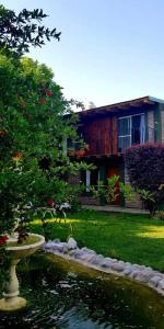 ein Haus mit einem Teich vor einem Haus in der Unterkunft Mi Jardín in San Rafael