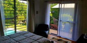 ein Schlafzimmer mit einem Bett und einem großen Fenster in der Unterkunft Mi Jardín in San Rafael