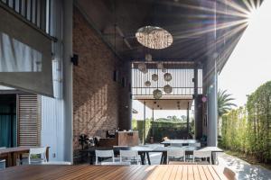 a restaurant with tables and chairs and a brick wall at Vann Hua Hin Resort in Cha Am