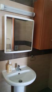 un baño con lavabo y espejo en Kerynia Apartments, en Pafos 144 fotos más