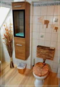uma casa de banho com um WC em madeira e um armário em Ferienwohnung Heideschwedin l em Eschede