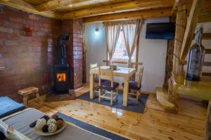 a living room with a table and a wood stove at Durmitorske zore in Žabljak
