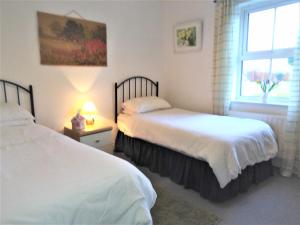 two beds in a room with a window at Ravens Oak, West Cork in Bantry
