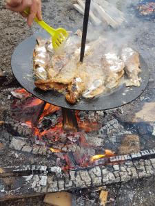 a person cooking meat on a grill with a spatula at La Casieru in Bilbor