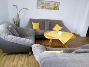 un soggiorno con divano e tavolo di Ferienwohnung Familie Schneider a Neustadt in Sachsen