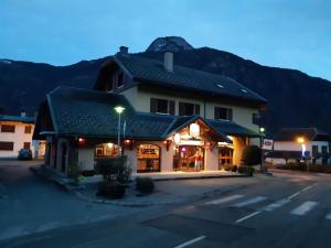 a building in a parking lot with a mountain in the background at Le Grand Chatelard HÔTEL BAR RESTAURANT in Sainte-Marie-de-Cuines