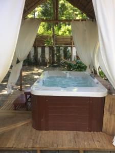 a jacuzzi tub on a wooden deck with a tent at Puerto Galera Hostel in Puerto Galera