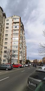 ピアトラ・ネアムツにあるApartament centralの高層ビルの前に車を停めた街道