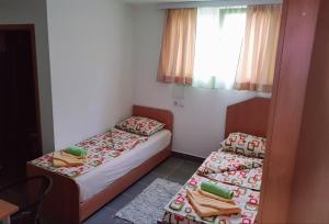 a small room with two beds and a window at Studio Isakovic Centar in Soko Banja