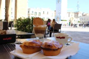 einen Tisch mit zwei Muffins und einer Tasse Kaffee in der Unterkunft Duecuori & Una spa in Lecce