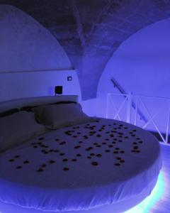Schlafzimmer mit einem Bett mit lila Beleuchtung in der Unterkunft Duecuori & Una spa in Lecce