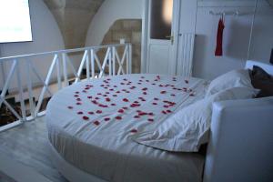 ein weißes Bett mit roten Herzen drauf in der Unterkunft Duecuori & Una spa in Lecce