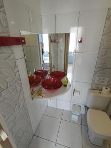 a bathroom with two red sinks and a toilet at Pousada Solar Azul in Lençóis +71 photos