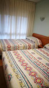 dos camas sentadas una al lado de la otra en una habitación en Hospedaje Covadonga, en Gijón