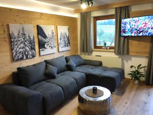ein Wohnzimmer mit einem blauen Sofa und einem Tisch in der Unterkunft Schwarzenbergerhof in Reith im Alpbachtal