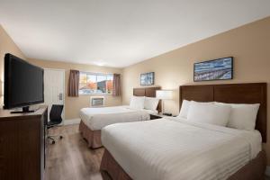 Voodi või voodid majutusasutuse Travelodge by Wyndham Salmon Arm BC toas