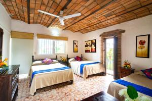 a bedroom with two beds and a ceiling fan at Hotel Posada De Roger in Puerto Vallarta +37 photos