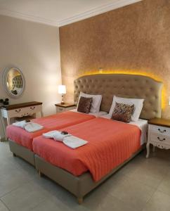 a bedroom with a large bed with two towels on it at Knights' Castle Studios in Archangelos