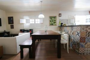 uma cozinha com uma mesa e uma sala de jantar em Lindo Privê 04 Suítes com AR, 5WC e Grande Piscina em Gravatá