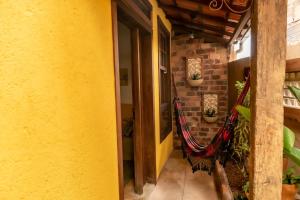 a room with a yellow wall and a hammock at Chalé Diamantina in Diamantina