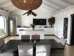a kitchen and dining room with a black table and chairs at Taveuni Palms Resort in Matei