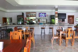 un bar con mesas de madera y sillas en un restaurante en Cabinas Sueño Real en San Rafael