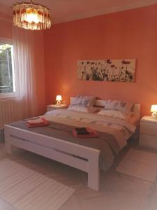 1 dormitorio con 1 cama grande y paredes de color naranja en Fioretta en Mali Lošinj