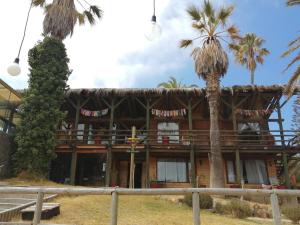 a building with palm trees in front of it at Hotel Green Papudo in Papudo