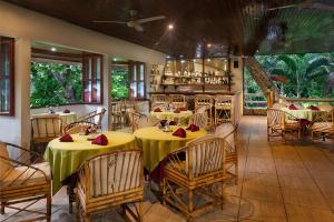 ein Restaurant mit 2 Tischen und Stühlen mit gelben Tischen in der Unterkunft Hotel Playa Bejuco in Esterillos Este