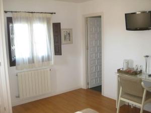 a white room with a window and a desk and a window istg at Hostal Tabanqueta in Cuenca