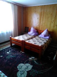 ヤレムチャにあるSadyba Zavitaikoのベッドルーム1室(木製ベッド1台、紫色の枕付)