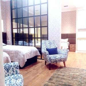 a bedroom with a bed and a chair and a mirror at Nova city center apartments in Tbilisi City