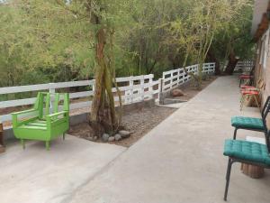 een groene bank naast een wit hek bij Hospedaje Rural Casa de Felix in San Pedro de Atacama
