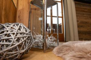 een glazen kast op een houten vloer naast een bal bij Appartements Lehenhof in Sankt Johann im Pongau