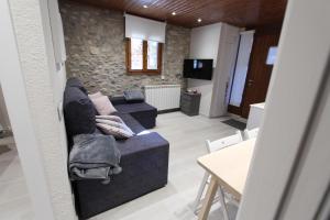 sala de estar con sofá y mesa en Apartaments Cal Bertran, en Bellver de Cerdanya 