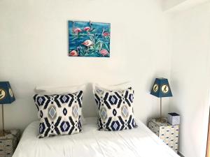 ein Schlafzimmer mit einem Bett mit zwei Kissen und einem Gemälde in der Unterkunft La Maison du Courtil, Pistache-Chocolat in Moustiers-Sainte-Marie