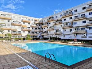 a swimming pool in front of a large apartment building at VV Sweet Home Playa del Inglés "by henrypole home" in San Bartolomé