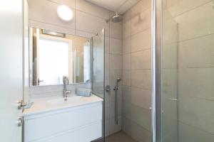 a bathroom with a sink and a shower with a mirror at Hilton Bay Apartment with Bedroom shelter in Tel Aviv +6 photos
