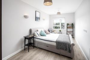 a white bedroom with a bed and a window at Vertex Luxury Suite in Croydon