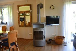a living room with a stove and a television at Ferienhaus "et Eifelparadiesje" in Gerolstein
