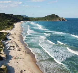 Una spiaggia con un sacco di gente che ci cammina sopra di Recanto Vó Terezinha a Imbituba