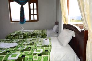 - 2 lits dans une chambre avec un cygne sur le lit dans l'établissement Quilotoa Green Lake, à Quilotoa