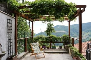 a chair on a patio with a view of mountains at Hiking Escape Parzanica in Parzanica