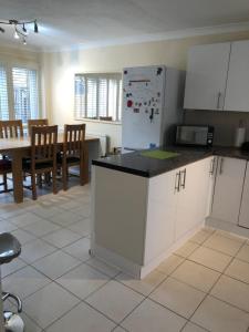 a kitchen with a refrigerator and a table with chairs at Deptfort House - 7 Minutes to London Bridge Station in London