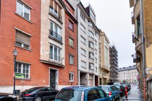 Une rangée de voitures garées dans une rue à côté des bâtiments dans l'établissement Diamond Residence - Marble Apartment, à Budapest